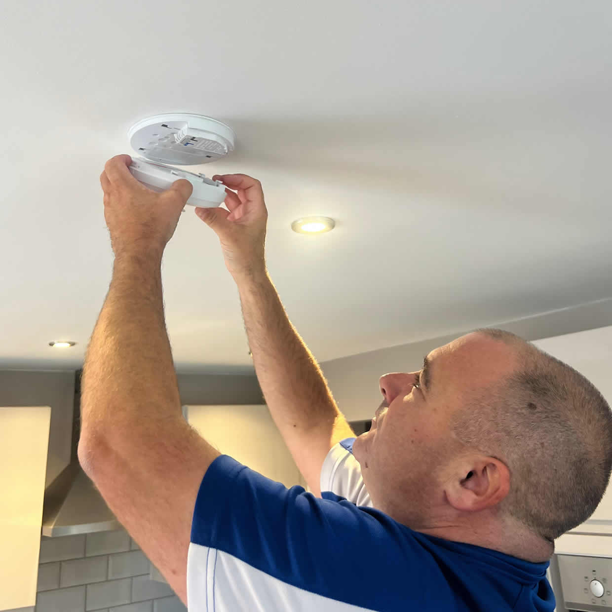 Smoke alarm installer fitting a detector in a Tipton DY4 property